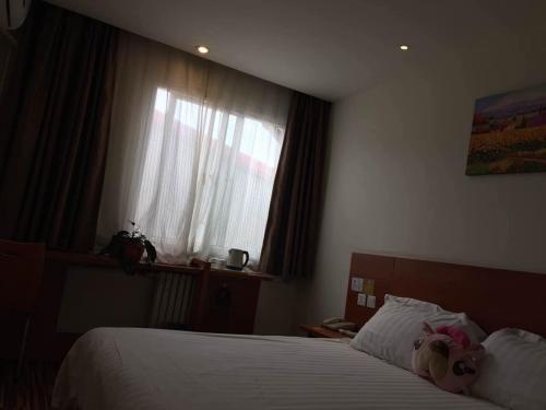 a hotel room with a bed and a window at Goldmet Inn Beojing Capital Airport Xinguozhan in Shunyi