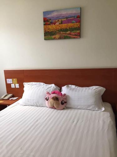 a stuffed animal sitting on top of a bed at Goldmet Inn Beojing Capital Airport Xinguozhan in Shunyi