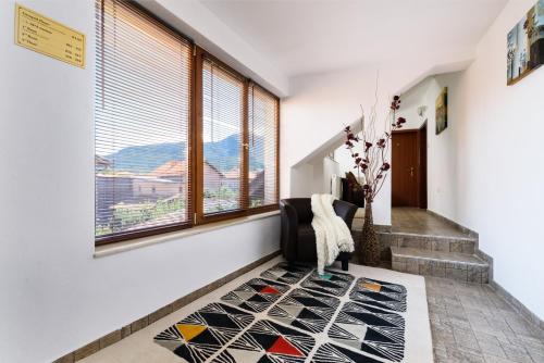 a hallway with a window and a rug at Velinov Boutique Hotel in Bansko