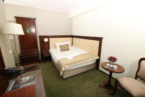 a hotel room with a bed and a table at Hotel Carmen in Predeal