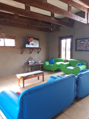 a living room with blue couches and green chairs at Kosi Bay Lodge in Manguzi