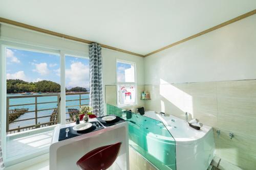 a bathroom with a sink and a large window at Dolsanmaru Pension in Yeosu