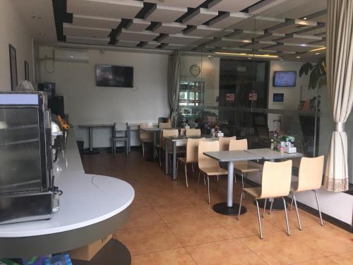 a dining room with tables and chairs in a restaurant at Goldmet Inn Beojing Capital Airport Xinguozhan in Shunyi