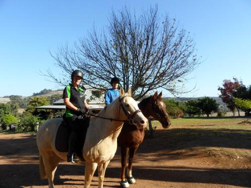 two people are riding on horses in a field at Balinga Cottages in Balingup