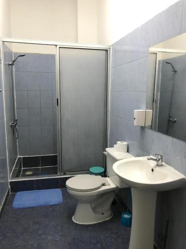 a bathroom with a shower and a toilet and a sink at Hostal Tricontinental in Valparaíso