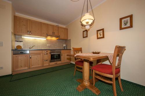 a kitchen with a table and chairs and a chandelier at Gästehaus Lärchenhang in Mittenwald