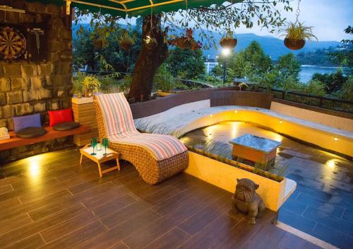 a patio with a dog sitting next to a pool at Lavasa Luxury Deck Apartment in Lavasa