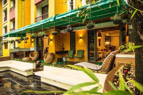 a building with a patio with tables and chairs at Lavasa Luxury Deck Apartment in Lavasa