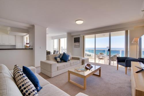 a living room with a couch and a table at Xanadu Resort in Gold Coast