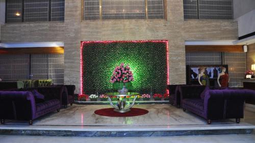 a lobby with purple furniture and a green wall at SkyCity Hotel Gurgaon in Gurgaon