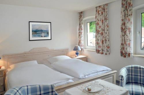 バート・ベルネック・イム・フィヒテルゲビルゲにあるHotel Haus Bauerのベッドルーム1室(ベッド1台、椅子2脚付)