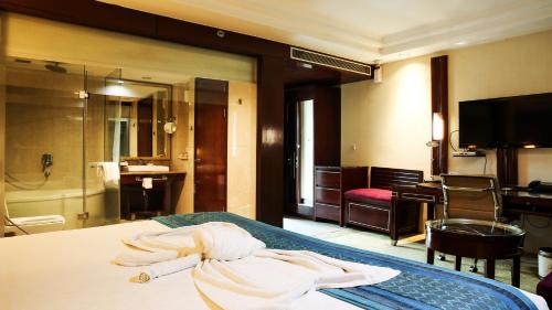 a hotel room with a bed with towels on it at SkyCity Hotel Gurgaon in Gurgaon