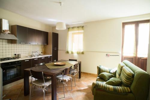 a kitchen and living room with a table and a couch at ARAS b&b - in Mazzarino