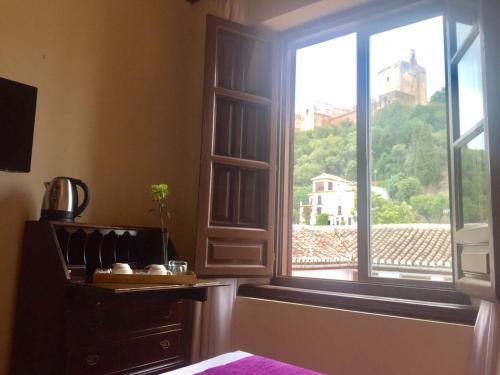 a room with a window with a view of a building at Palacio de Santa Inés in Granada
