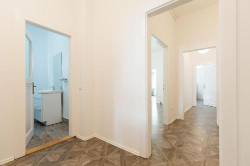 un pasillo vacío con paredes blancas y espejo en M&F Apartment, en Brasov