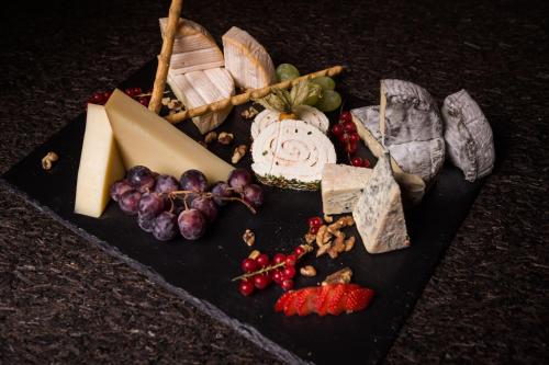 a bunch of different types of cheese and fruit on a table at Aktivhotel Alpendorf in Sankt Johann im Pongau