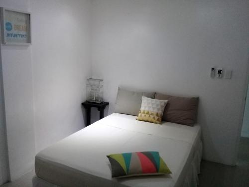 a bedroom with a white bed with a pillow on it at Sergi's Resort and Hotel in Palompon