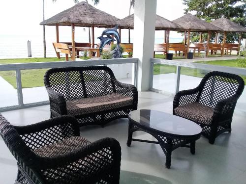 a group of chairs and a table on a porch at Sergi's Resort and Hotel in Palompon