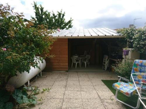 a shed with a table and chairs in a garden at Maison De Village in Barbechat