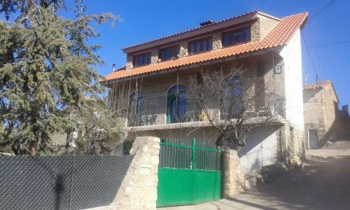 una casa con una puerta verde y una valla en Casa Rural Chulilla, en Villarroya de los Pinares