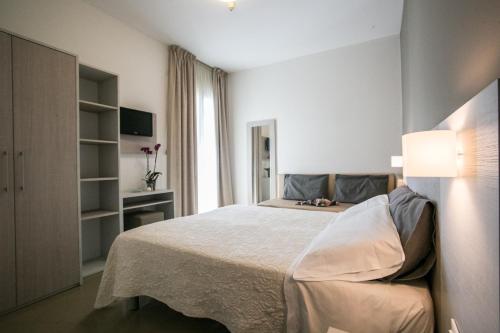 um quarto com uma cama grande e uma janela em Hotel Caesar em Rimini