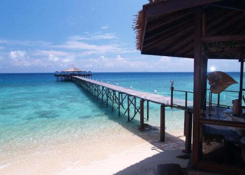 a pier in the water next to the ocean at Japamala Resort by Samadhi Age 12 and Above Only in Tioman Island