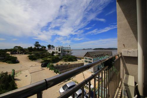 a balcony with a view of a street and the ocean at Hotel Hue Loft in Incheon