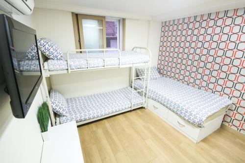 a room with two bunk beds and a mirror at Zaza Backpackers hostel in Seoul