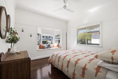 a white bedroom with a bed and a window at The Lighthouse in Toowoomba