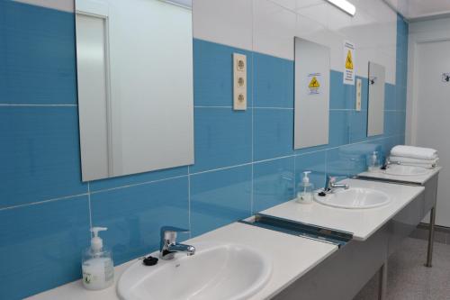 La salle de bains est pourvue de 2 lavabos et d'un miroir. dans l'établissement Albergue Valle del Nonaya, à Salas