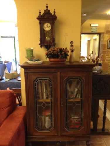 a wooden cabinet with a clock on the wall at Hotel Palacio De La Viñona in Oviedo