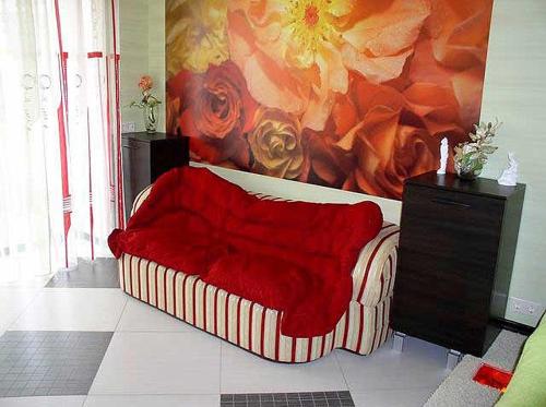 ヘルソンにあるDzhon Govard Studioの絵画のある部屋の赤いソファ