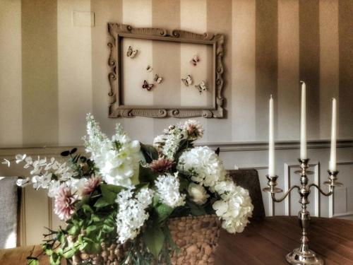 una mesa con dos velas y un espejo con flores en c'è posto per te, en Vasto