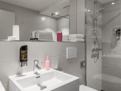 La salle de bains est pourvue d'un lavabo et d'une douche. dans l'établissement Serways Hotel Siegburg West, à Siegburg