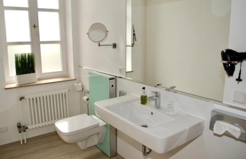a white bathroom with a sink and a toilet at Alt Warburg in Warburg