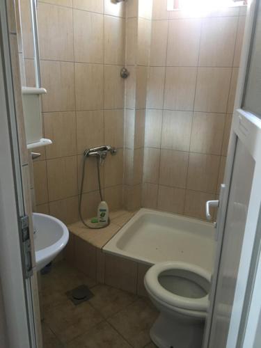 a bathroom with a tub and a toilet and a sink at Bujtina (Pension) Oltas in Prizren