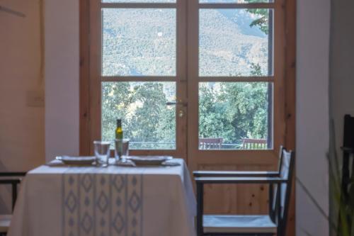 卢克松阿尔兹内斯农家乐的一张桌子,上面放着一瓶葡萄酒,还有一个窗口