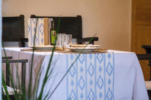 卢克松阿尔兹内斯农家乐的一张带白色桌布和一瓶葡萄酒的桌子