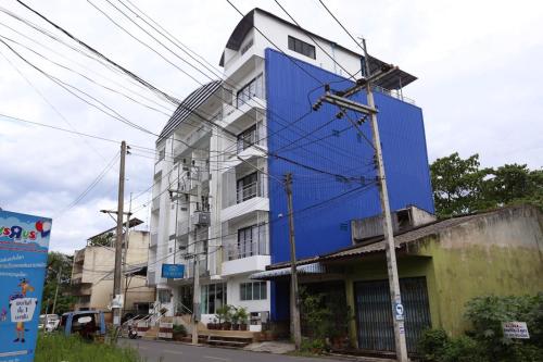 a blue building on the side of a street at Chamnan Residence in Hat Yai