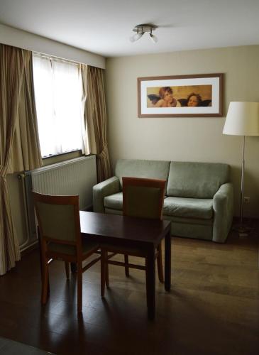 a living room with a couch and a table at Hotel De Schacht in Genk