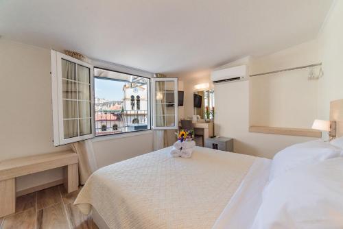 a bedroom with a bed with two teddy bears on it at Castello Boutique Rooms in Kavala