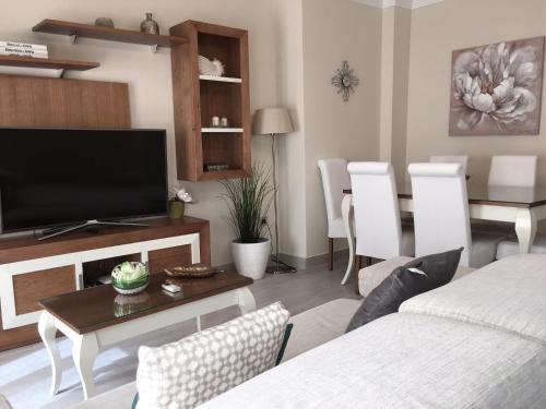 a living room with a television and a table at New Apartments Ronda in Ronda