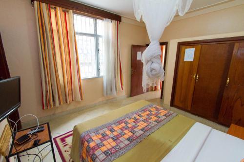a bedroom with a bed and a window at Kings Hospitality Centre in Kigali