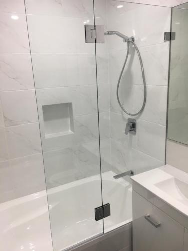 a shower with a glass door next to a sink at Fremantle Harbour Townhouse in Fremantle