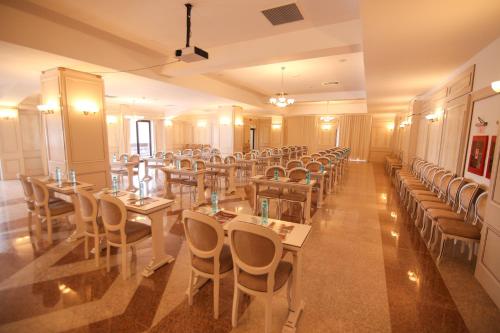 a banquet hall with tables and chairs in a room at Hotel Carmen in Predeal