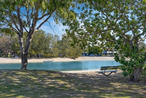 a park bench sitting next to a body of water at Excellsior Apartments in Mooloolaba