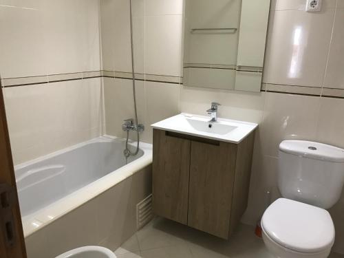 een badkamer met een wastafel, een toilet en een bad bij rua da Lota in Manta Rota