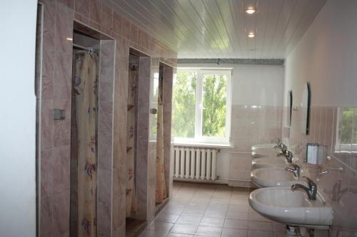 La salle de bains est pourvue de 3 lavabos et d'une rangée de miroirs. dans l'établissement Vydubychi, à Kiev