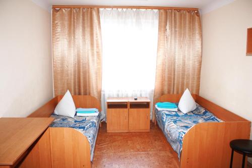 a small room with two beds and a window at Vydubychi in Kyiv
