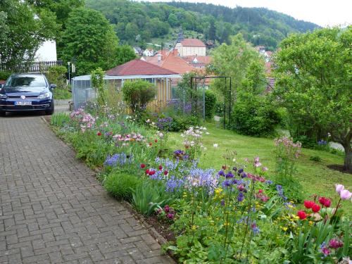 a garden with colorful flowers and a driveway at Fewo Zum alten Bergdoktor in Bad Liebenstein